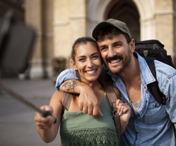 pareja-viajando-tomandose-selfie-juntos-ciudad-min